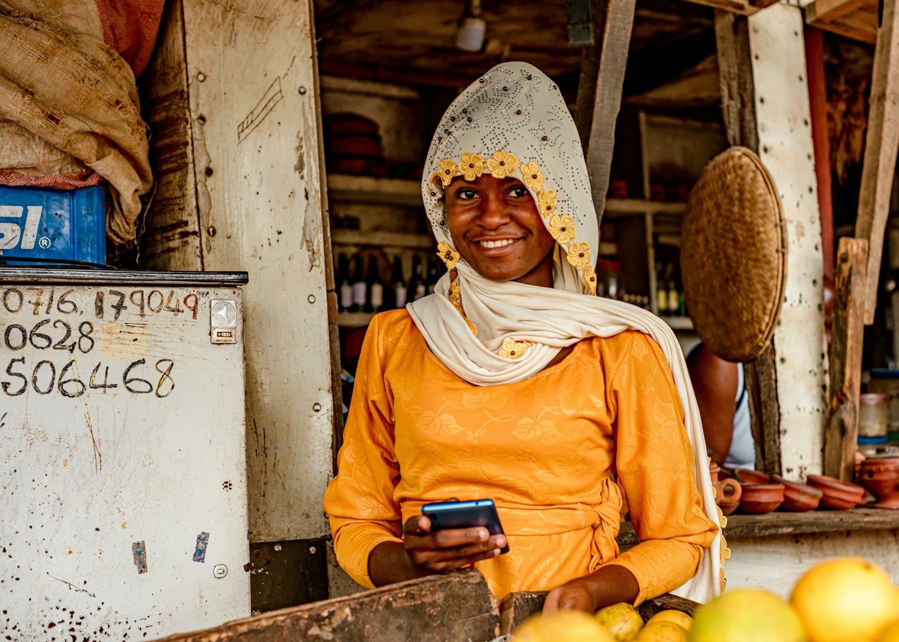 Une commerçante à son étal, téléphone à la main